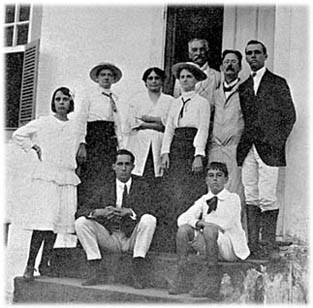 Adolpho Lutz na Fazenda Dietrich. Ao lado do cientista, de chapu, a sobrinha Gertrude e, mais adiante, trajando a mesma roupa, Paula. O guarda-p usado pelo cientista e pelo homem que parece ser o proprietrio da fazenda, no vo da porta, sugere que estavam realizando alguma atividade relacionada  coleta ou manipulao de espcimes biolgicos.